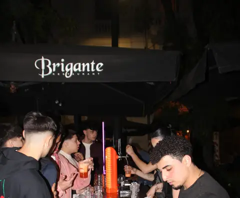 L’insegna Brigante sull’ombrellone sopra il bancone, di notte